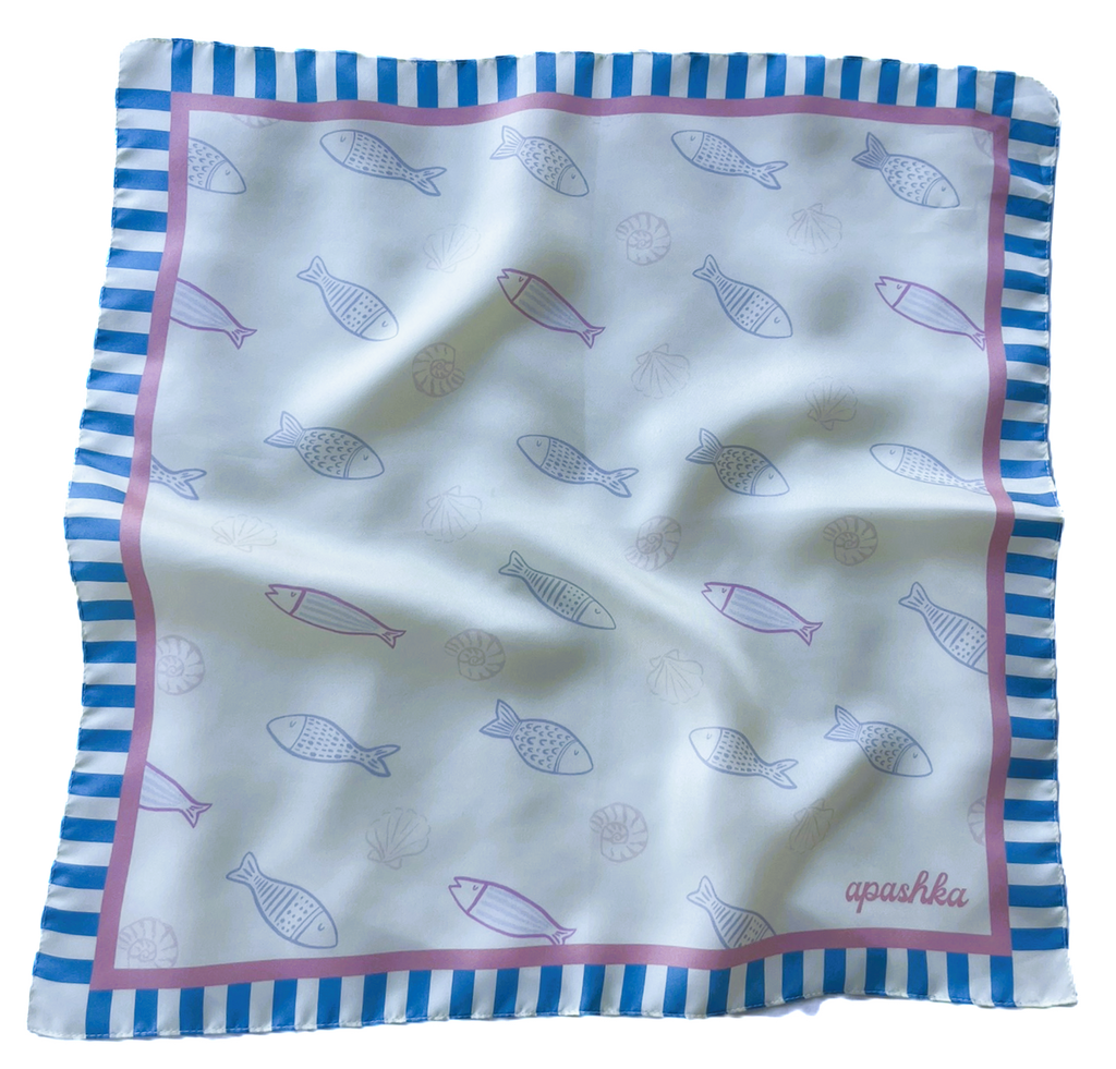 A flat lay view of the apashka Apashka Marina silk bandana laid out fully to show the complete fish pattern and striped border.