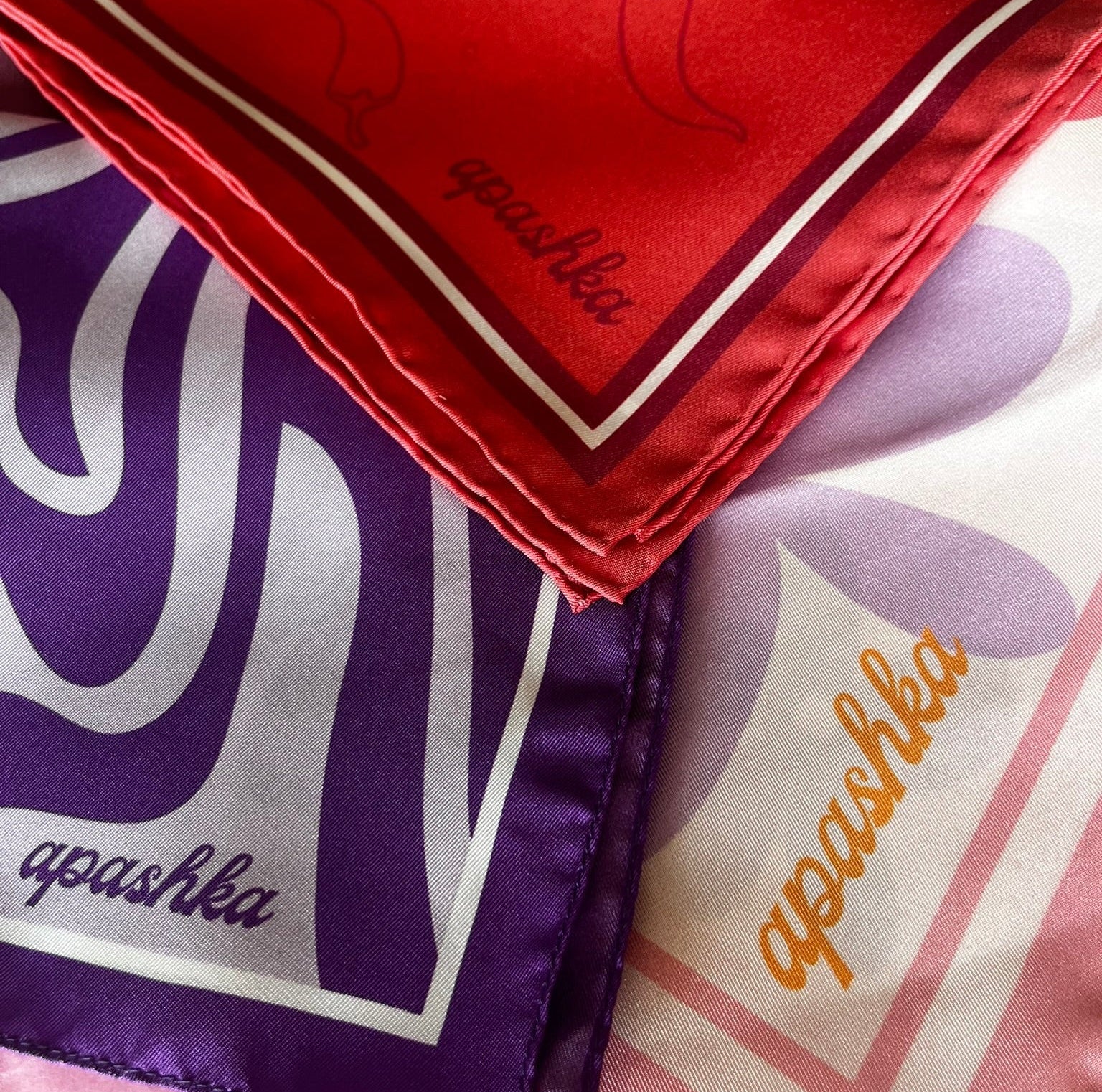 Three scarves with 'apashka' branding in different colors and patterns.