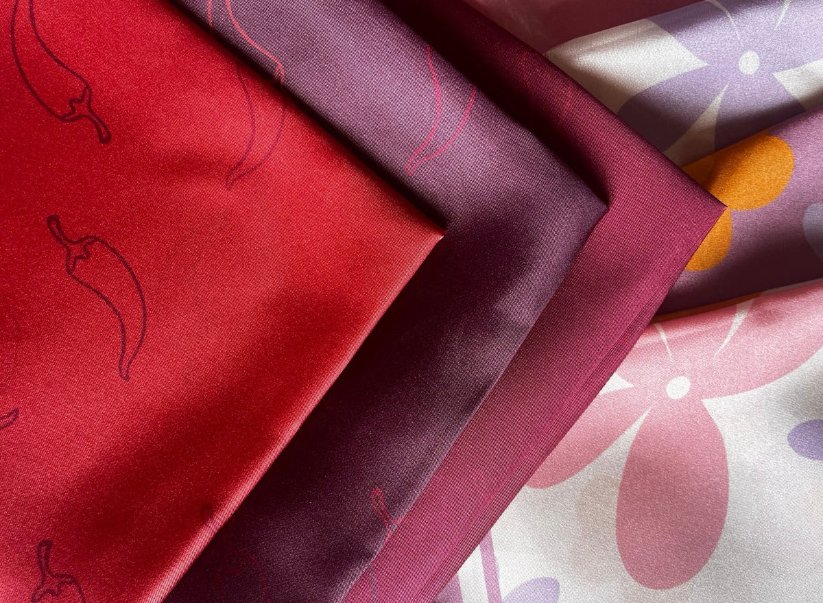 Close-up of foulard fabrics with chili pepper and floral patterns.