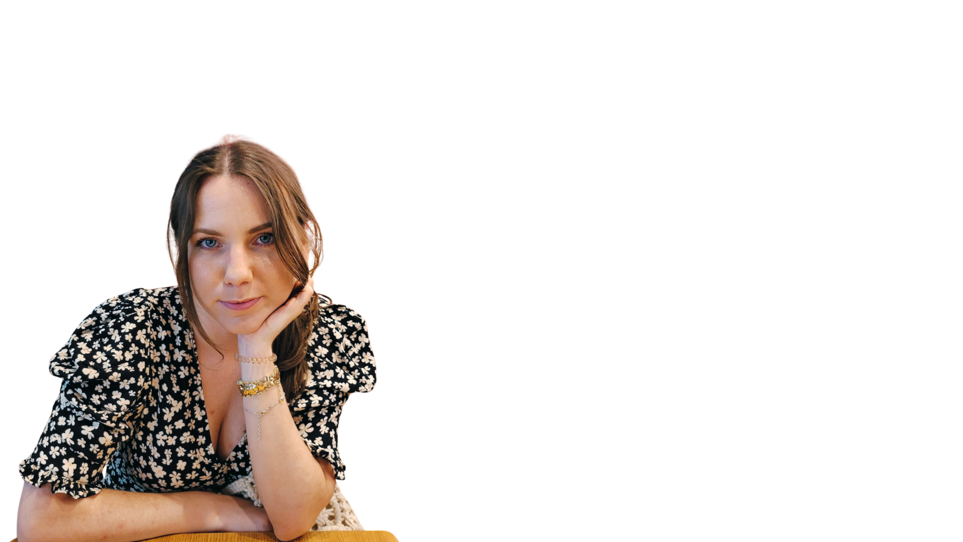 A woman sitting at the table wearing floral dress