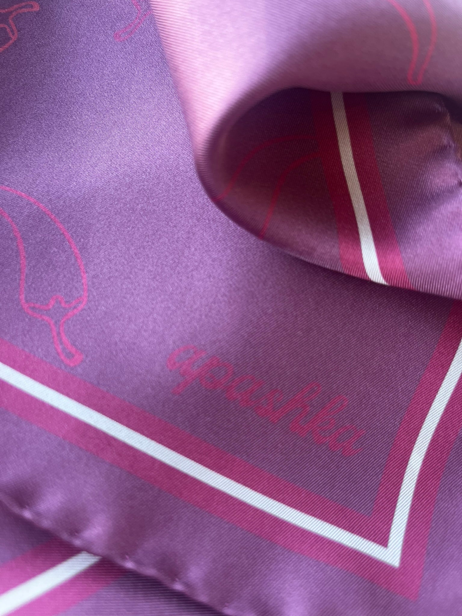 Close up of the signature apashka script logo on the corner of the Red Hot Chili Apashka in purple plum colour.