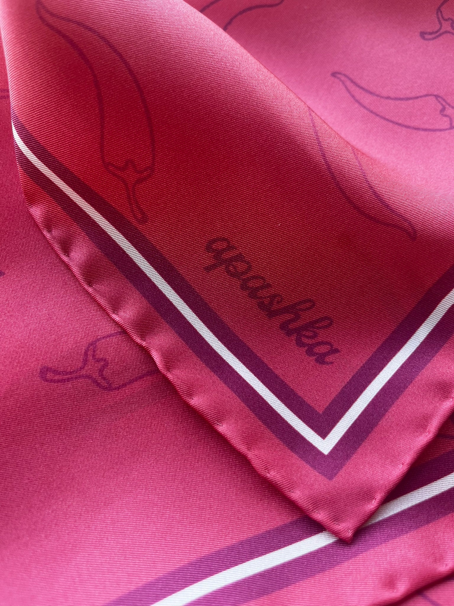 Close up of the signature apashka script logo on the corner of silk bandana and the hand rolled hem.