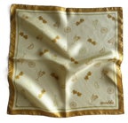 A top-down view of a square silk scarf slightly rippled and draped. The scarf has a warm cream-colored center scattered with an all-over gold orange art pattern of cocktails, lemon slices, and heart sunglasses, framed by a thick golden-yellow border.