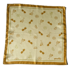 A flat, full-view layout of silk scarf. The scarf displays a repeated pattern of gold orange line-drawn cocktails, citrus wheels, and heart-shaped sunglasses, finished with a solid golden-orange border and the brand name "apashka" in the lower right corner.