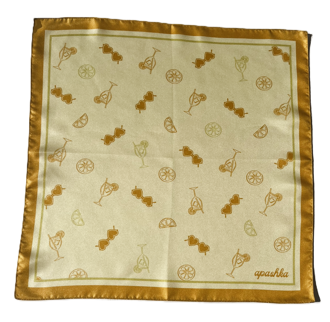 A flat, full-view layout of silk scarf. The scarf displays a repeated pattern of gold orange line-drawn cocktails, citrus wheels, and heart-shaped sunglasses, finished with a solid golden-orange border and the brand name "apashka" in the lower right corner.