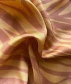 Close up of apashka Sunset Safari orange zebra silk bandana fabric folds with contrast hot pink hand-rolled hem.